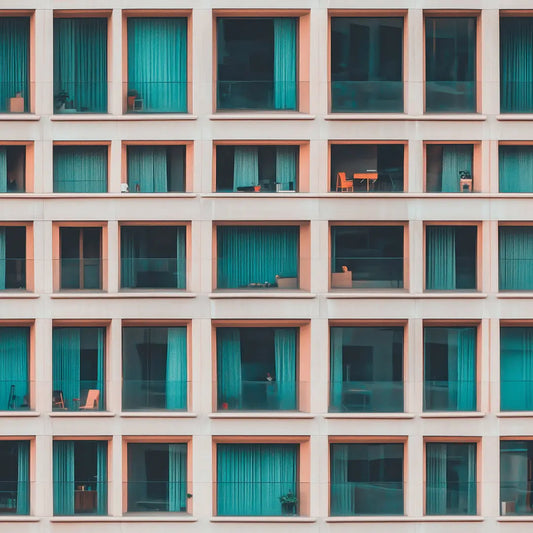 Detailansicht moderne Fassade mit grossen Fenstern und tuerkisfarbenen Vorhaengen