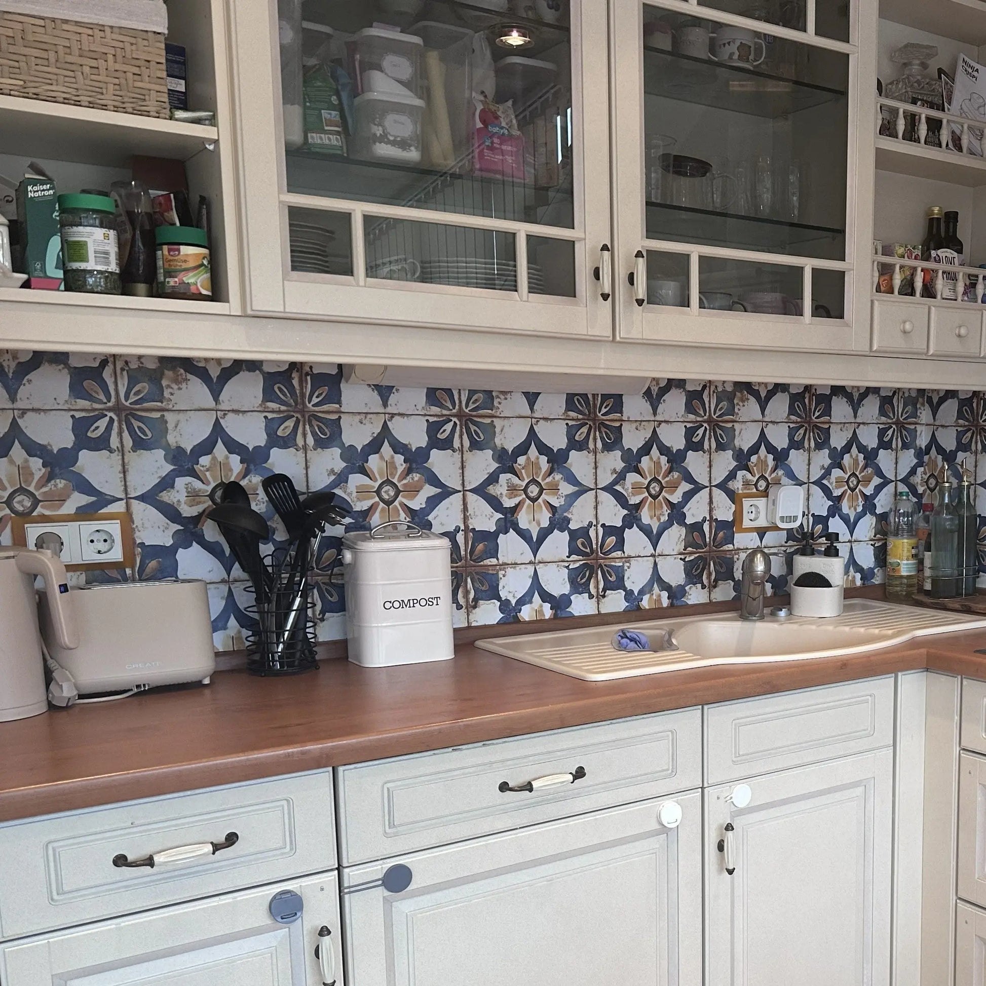 Fliesenfolie Azul Rustico – Echtfoto einer Kuechenrueckwand mit handbemalten mediterranen Fliesen in abwechselnden Blau- u...