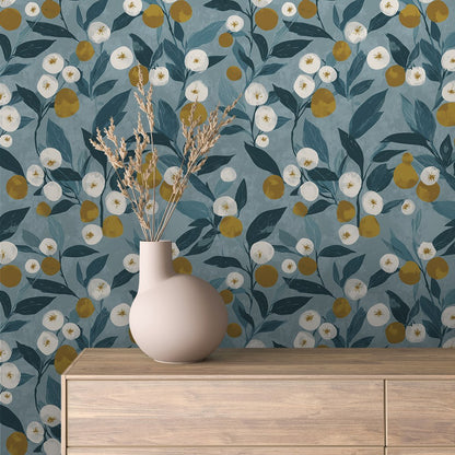 Blumentapete mit weißen Blüten und Zitrusfrüchten auf Petrol hinter einem Sideboard