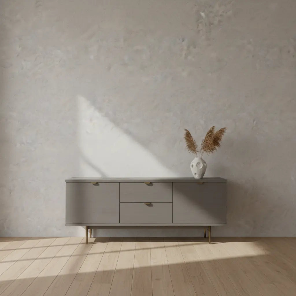 Selbstklebende Tapete Helle Betonoptik – Moderner Industrial Look mit feiner Struktur hinter grauem Sideboard auf Holzfußboden. Ideal für Wohnräume.