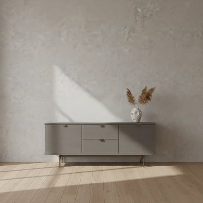 Selbstklebende Tapete Helle Betonoptik – Moderner Industrial Look mit feiner Struktur hinter grauem Sideboard auf Holzfußboden. Ideal für Wohnräume.
