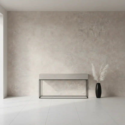 Selbstklebende Tapete Helle Betonoptik – Warmer Industrial Look mit sanfter Struktur in modernem Wohnraum mit Bank und schwarzer Vase.