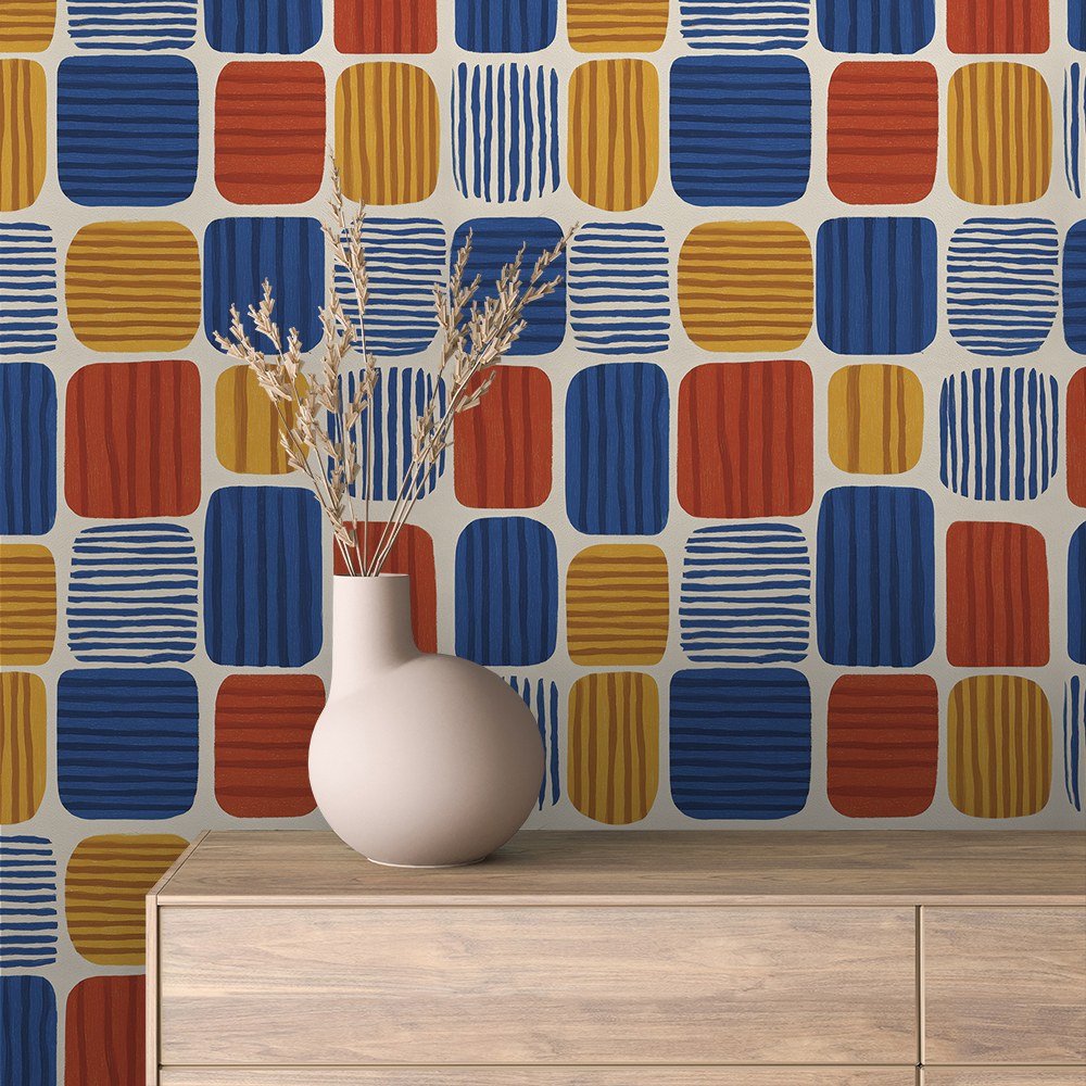 Retro Tapete mit bunten Kacheln in Blau, Orange und Gelb an der Wand hinter einem Sideboard